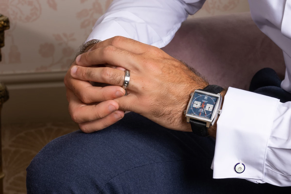 A person wearing a watch and adjusting his ring